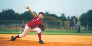 Young boy pitching baseball in a game